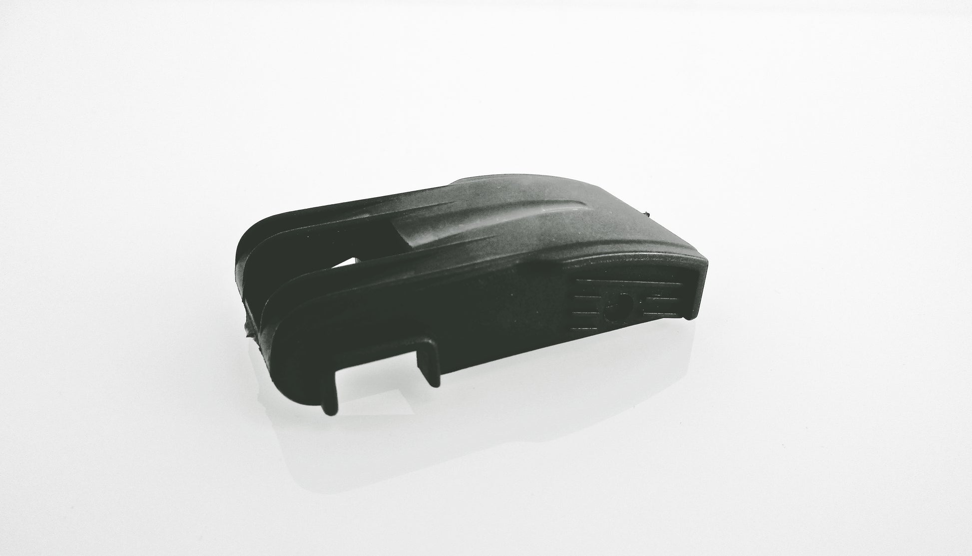 A black plastic air cleaner dust cup clip replacement part, shown on a plain white background. With a soft reflection underneath.