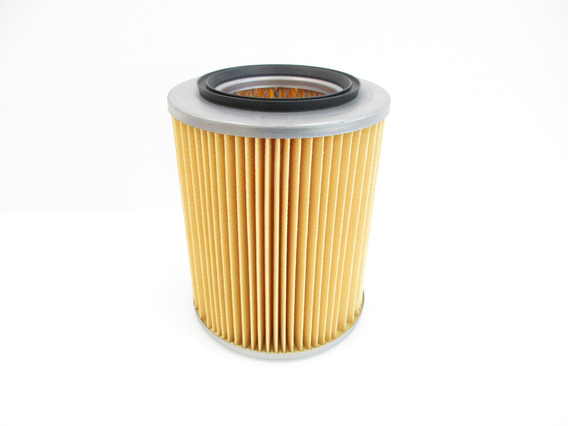 A pleated cylindrical air filter with a tan paper body, a grey metal top and bottom, and a black rubber gasket, shown on a white background.