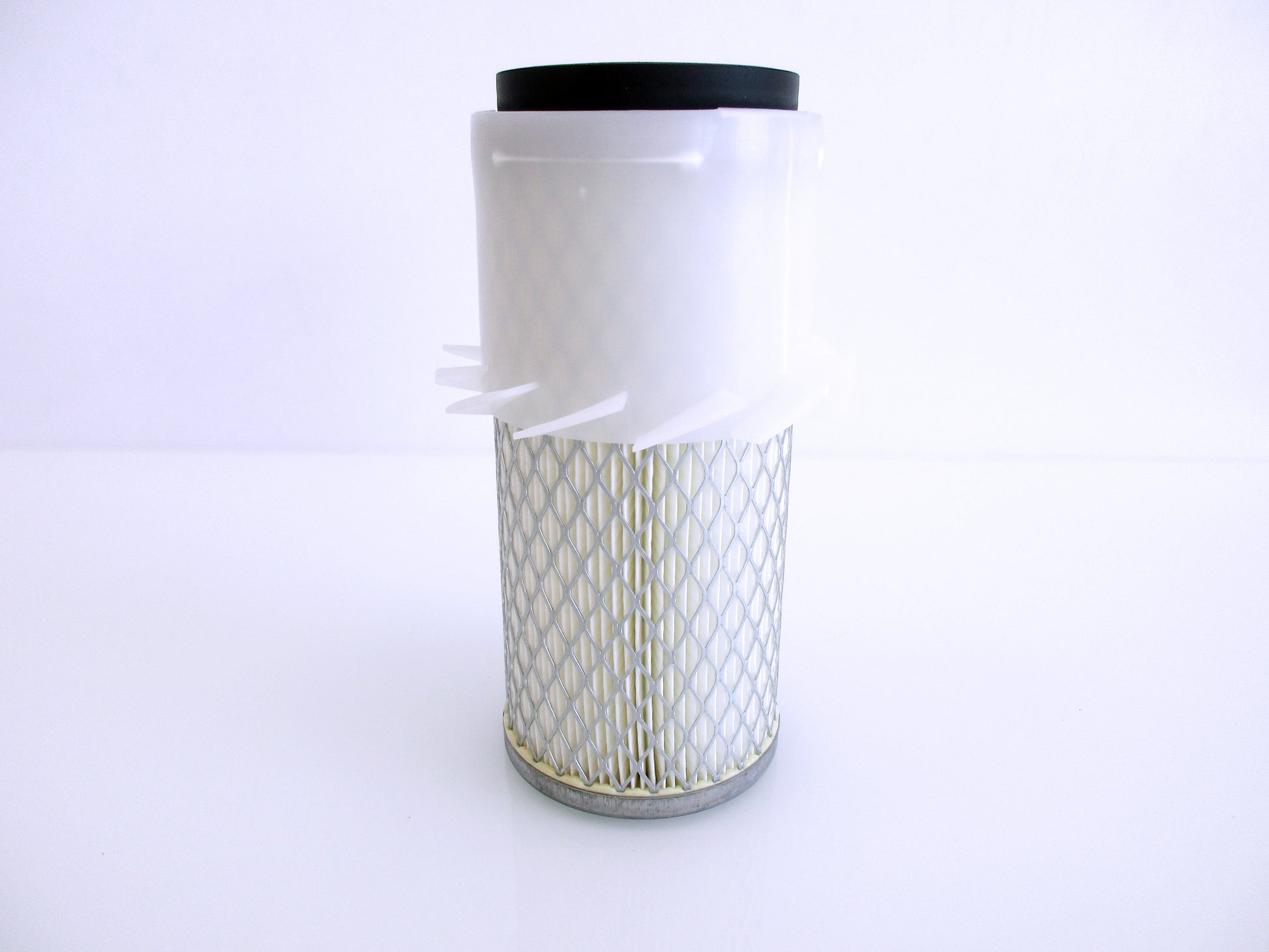 A cylindrical replacement air filter with a white plastic upper section with fins, a black seal top and a white pleated media surrounded by metal mesh, with grey base shown on a white background.