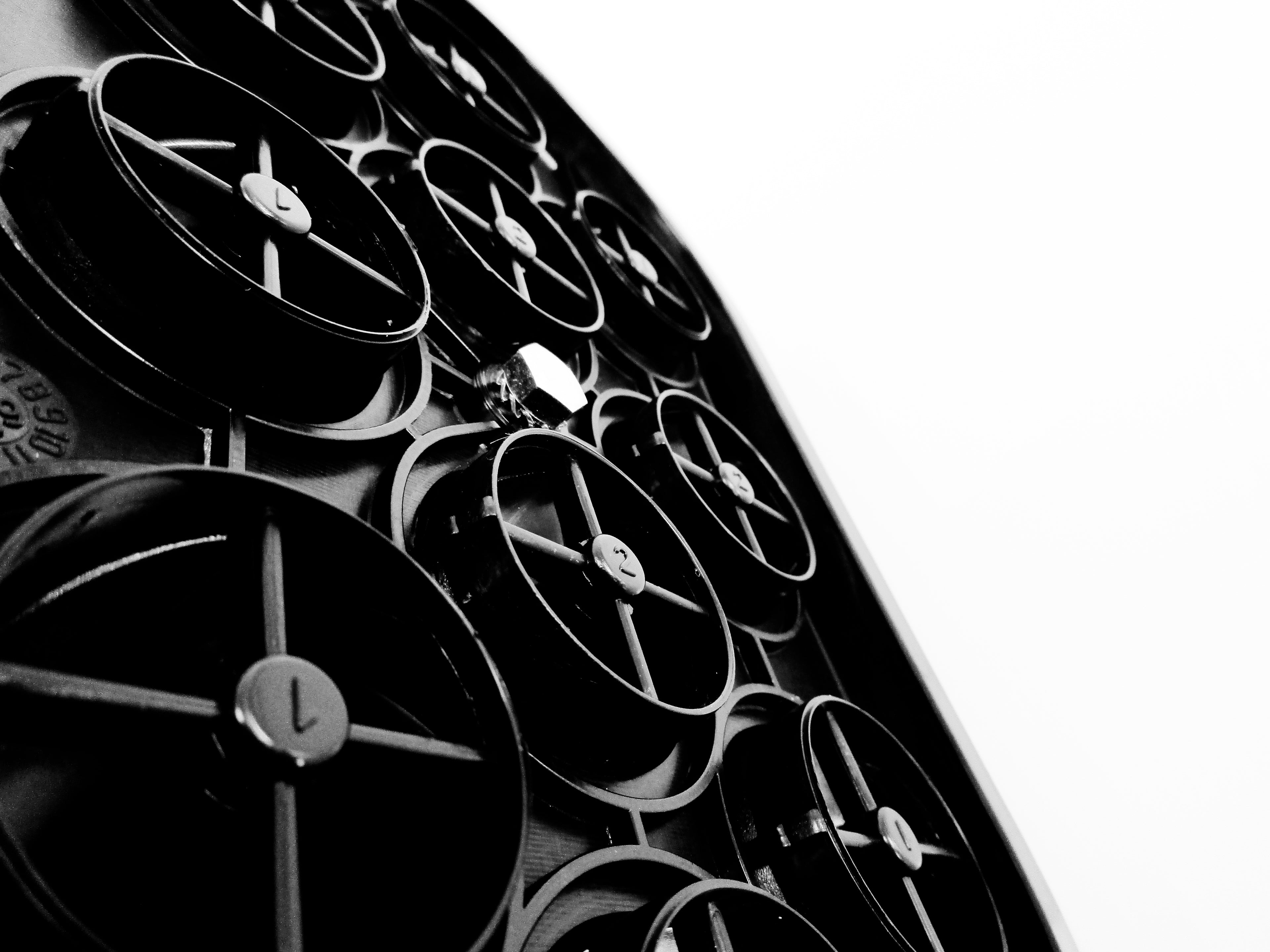 A close-up, angled view of a black Jokto air cleaner, showing its pre-cleaner inlets,  in high-contrast black and white against a white background.