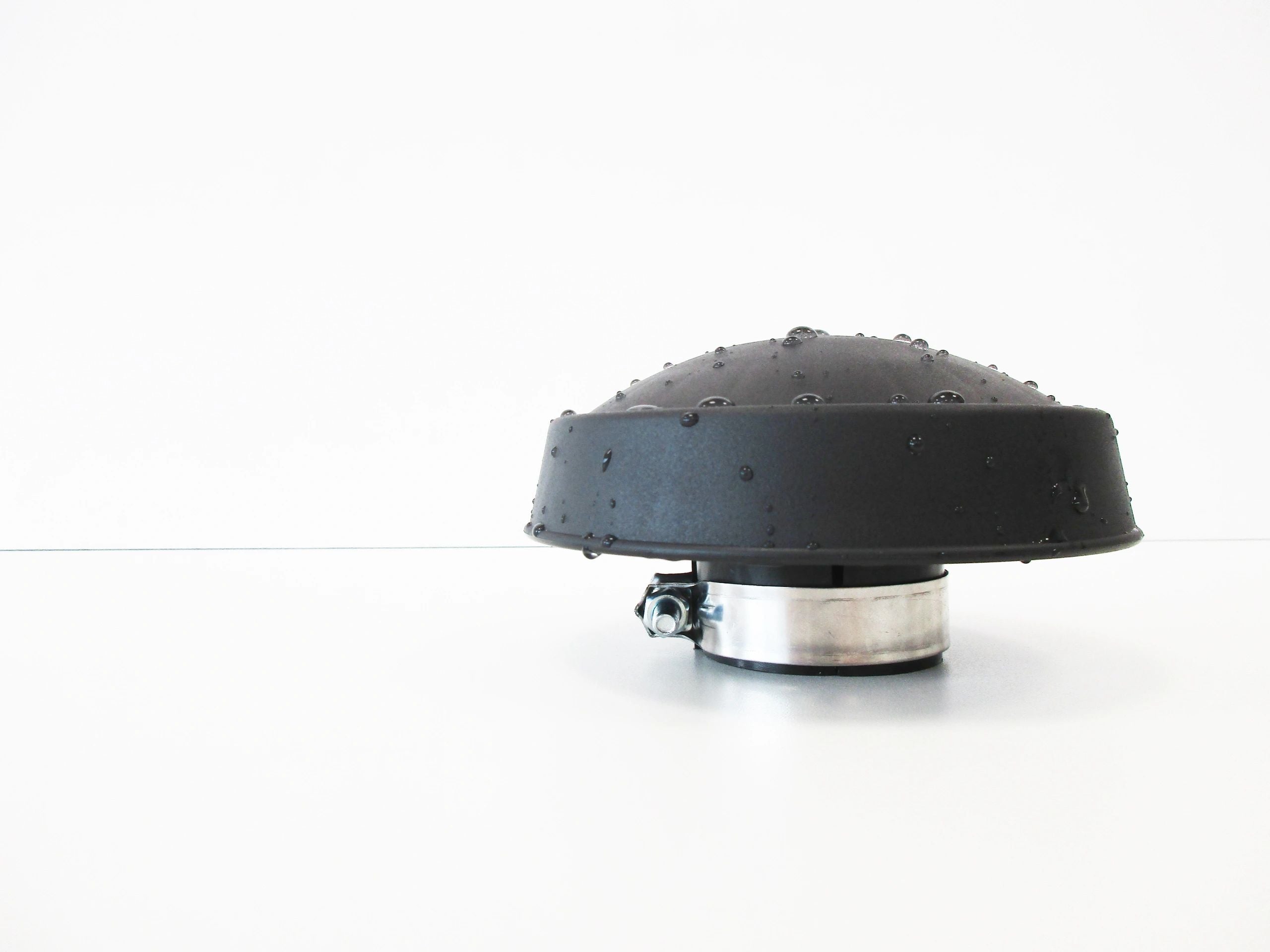 A black dome-shaped rain cap with water droplets on top, with a grey metal clamp, shown on a plain white background.