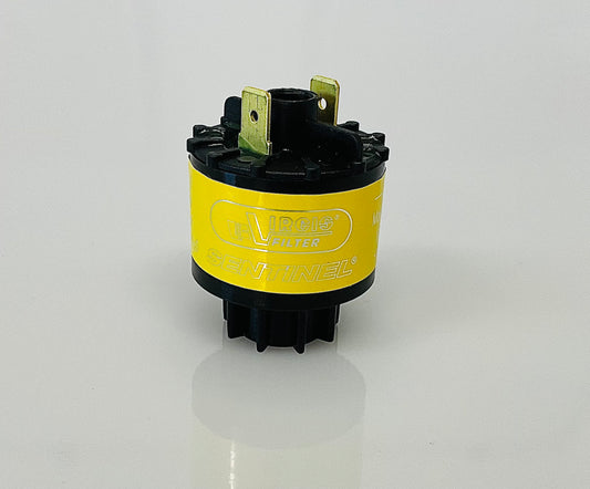 A small black cylindrical electrical indicator with two metal pins at the top, and a yellow label reading 'Virgis Filter' and 'Sentinel', shown on a reflective white surface.