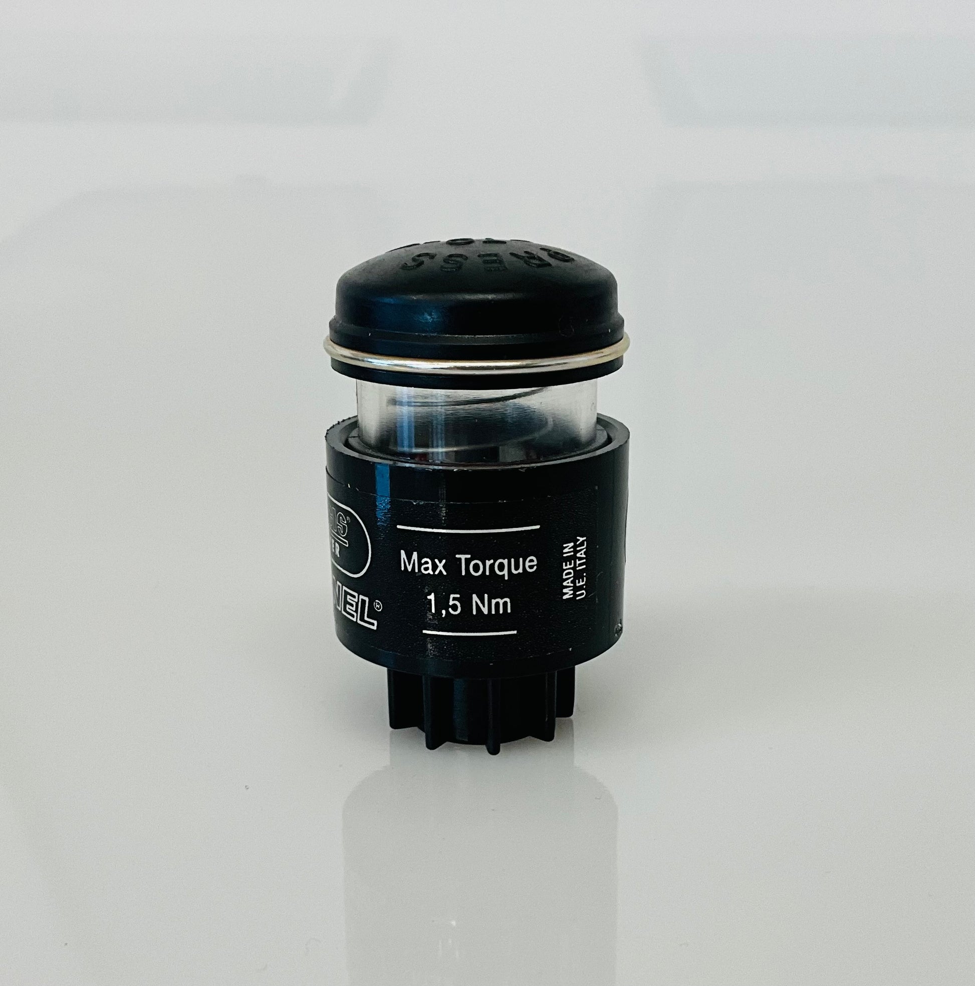 A small black cylindrical optical indicator with press button top, labelled 'Max Torque 1,5 Nm' and MADE IN U.E ITALY, shown on a reflective white surface. 