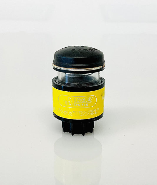 A small black cylindrical optical indicator with press button top, with a yellow label labelled 'Virgis Filter' and 'Sentinel', shown on a reflective white surface.